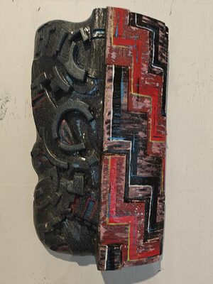 Carved panel in black and red with strong geometric patterns