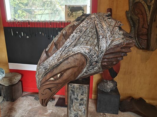 Carved bird-form sculpture on a stand in the gallery