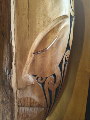Side profile of a face carved and painted on wood
