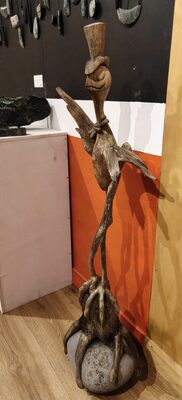Stone bird carving perched on a carved wooden base