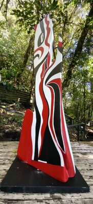 Bold red, white and black carved sculpture on a plinth